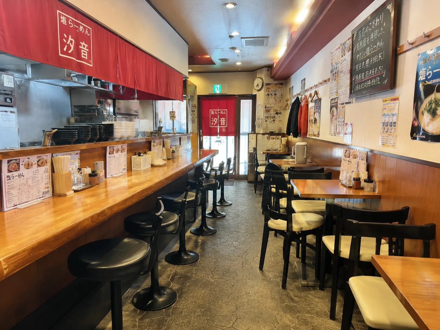 木のカウンターと赤い暖簾のある店内